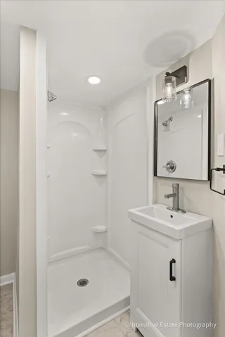 a bathroom with a sink a shower and a mirror