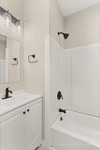 a bathroom with a tub sink vanity and shower