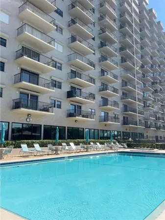 a view of building with swimming pool and seating
