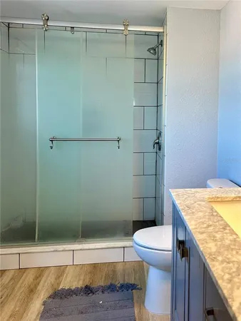 a bathroom with a granite countertop sink a toilet and mirror