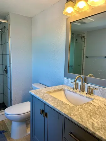 an empty room with wooden floor and fan