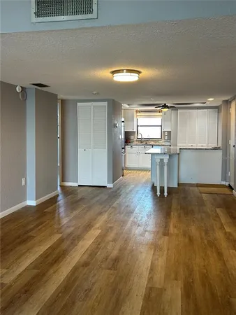a view of a kitchen with wooden floor and a window