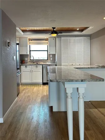 a kitchen with granite countertop a stove a sink and a refrigerator