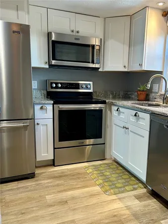 a kitchen with stainless steel appliances a stove a microwave and sink