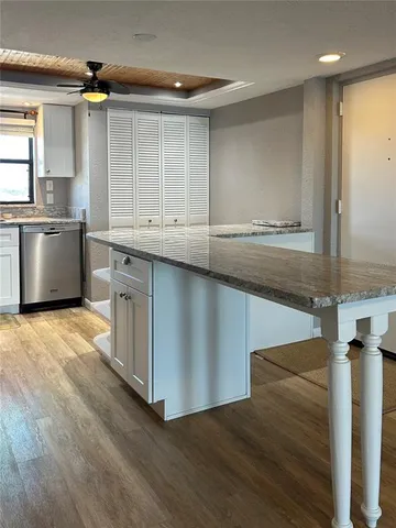 a kitchen with stainless steel appliances granite countertop a sink a stove and a wooden floors