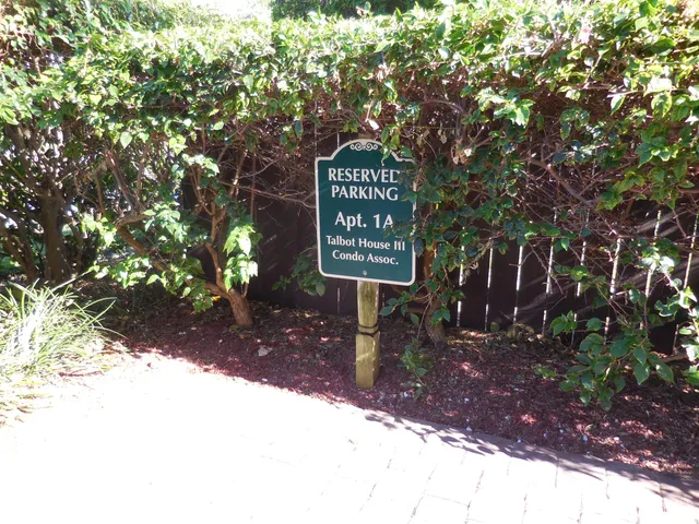 a sign that is sitting in front of a tree