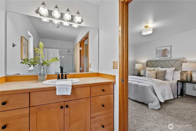 a en suite bathroom with a double vanity sink a mirror and a bathtub