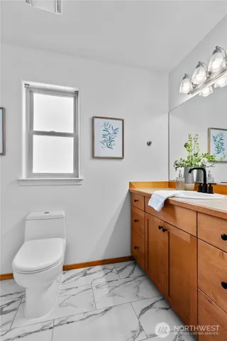 a spacious bathroom with a toilet sink and mirror