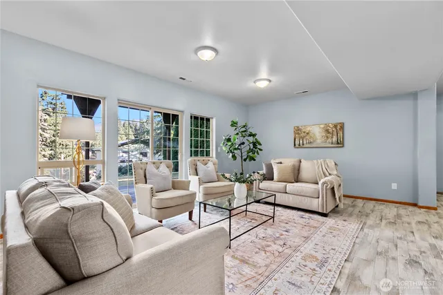 a living room with furniture potted plant and a large window