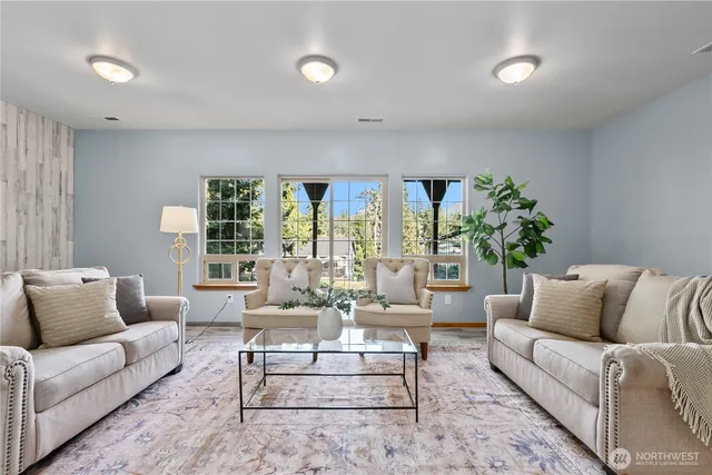 a living room with furniture and large windows