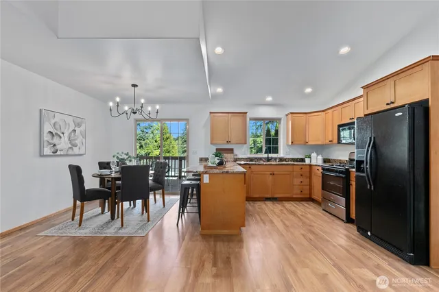 a kitchen with a refrigerator a dining table and chairs