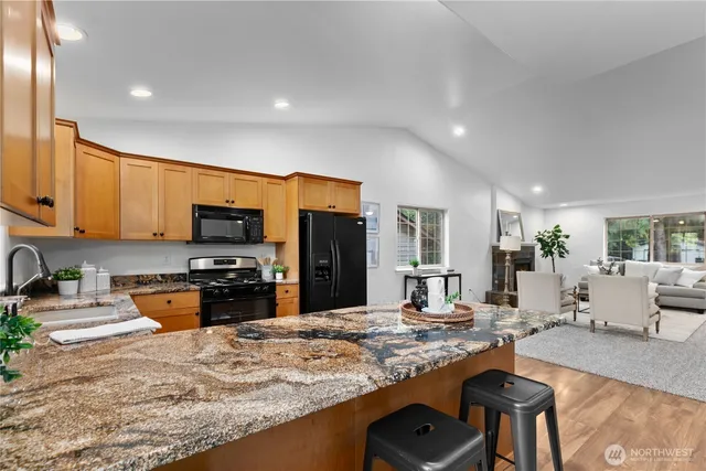a kitchen with stainless steel appliances granite countertop a sink stove and refrigerator