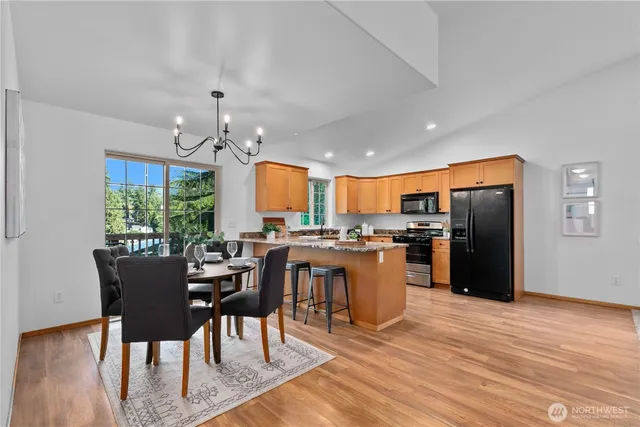 a kitchen with a table chairs refrigerator and cabinets