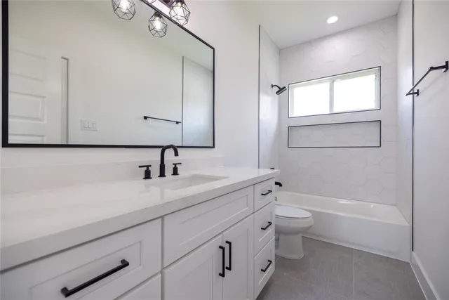 a bathroom with a double vanity sink a toilet and a tub
