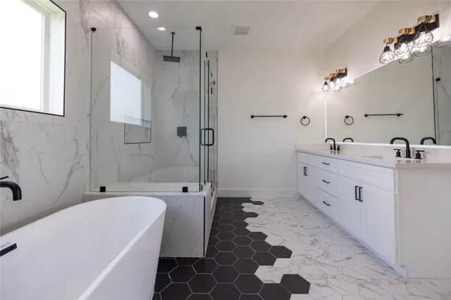 a bathroom with a tub sink toilet and shower