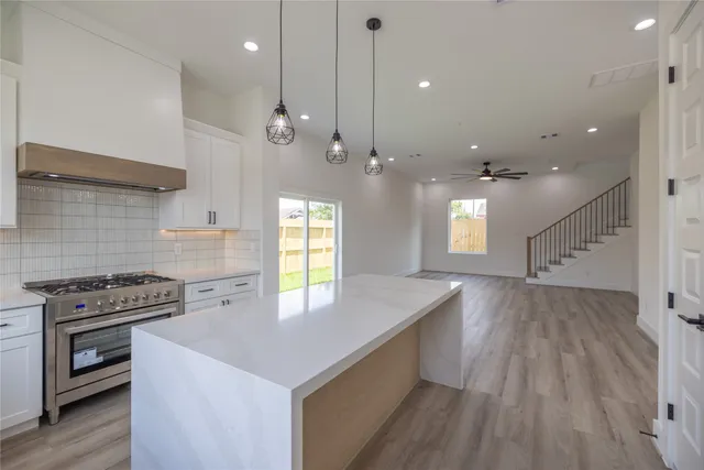 a kitchen with kitchen island a sink appliances and a counter top space