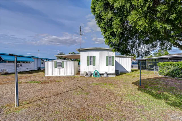 a view of a house with backyard and a tree