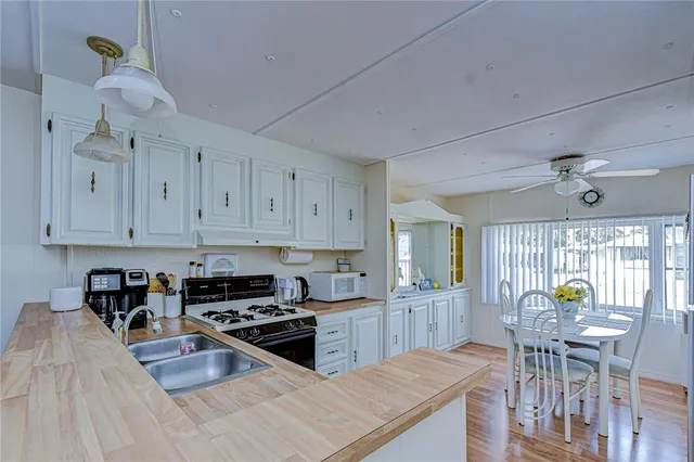a kitchen with granite countertop a stove a sink a dining table and chairs