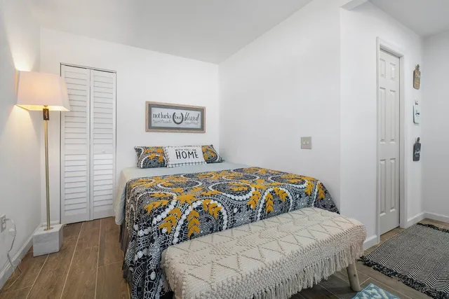 a bedroom with a large bed and a wooden floor