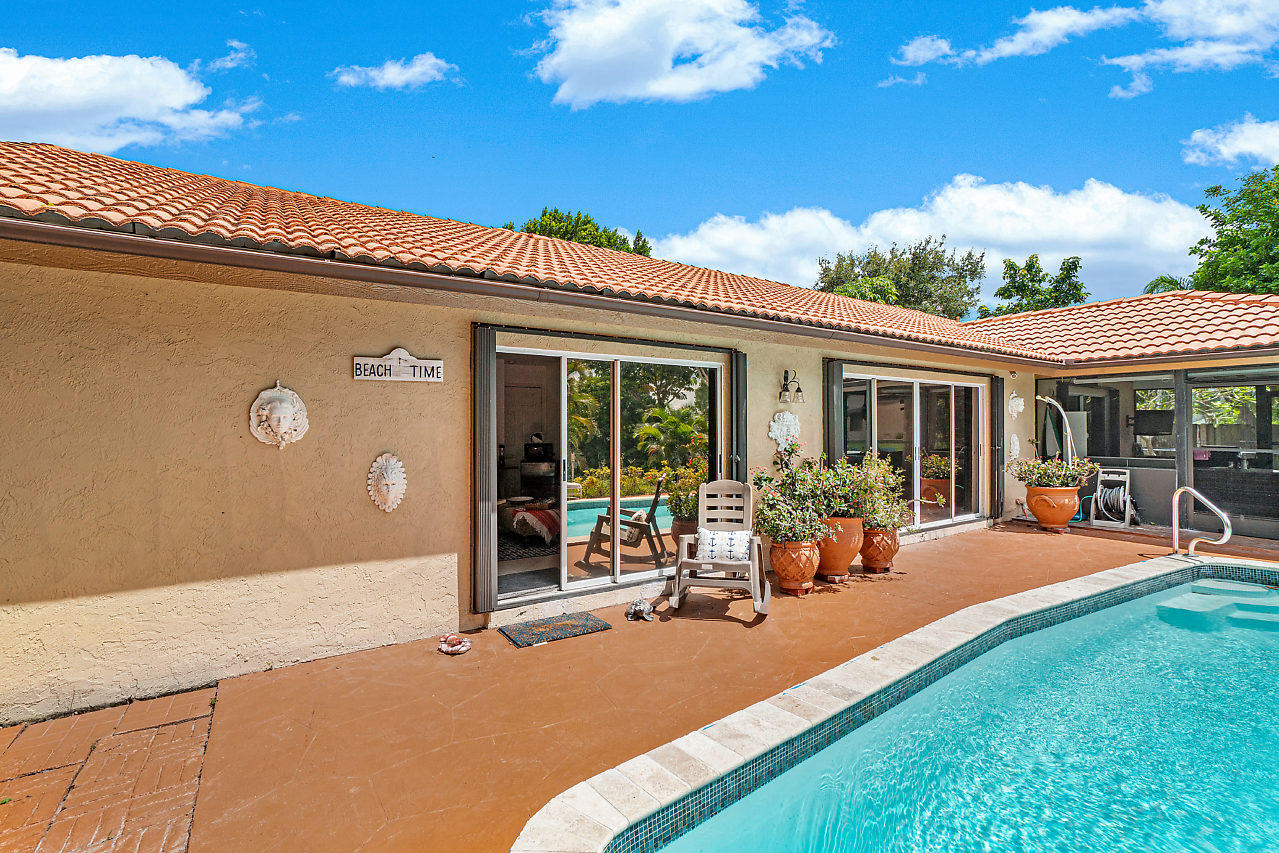 1401 Mystic Court, Unit 1BEDROOM GUESTHOUSE Wellington, FL 33414 - Photo 11 of 12 a backyard of a house with table and chairs with wooden floor