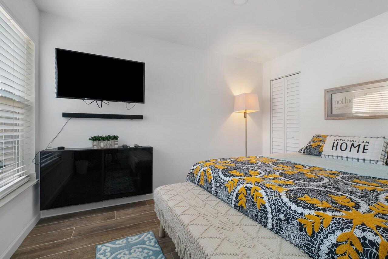 1401 Mystic Court, Unit 1BEDROOM GUESTHOUSE Wellington, FL 33414 - Photo 2 of 12 a bedroom with a bed and a flat screen tv