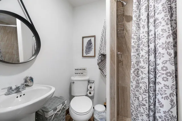 a bathroom with a toilet a sink and a mirror