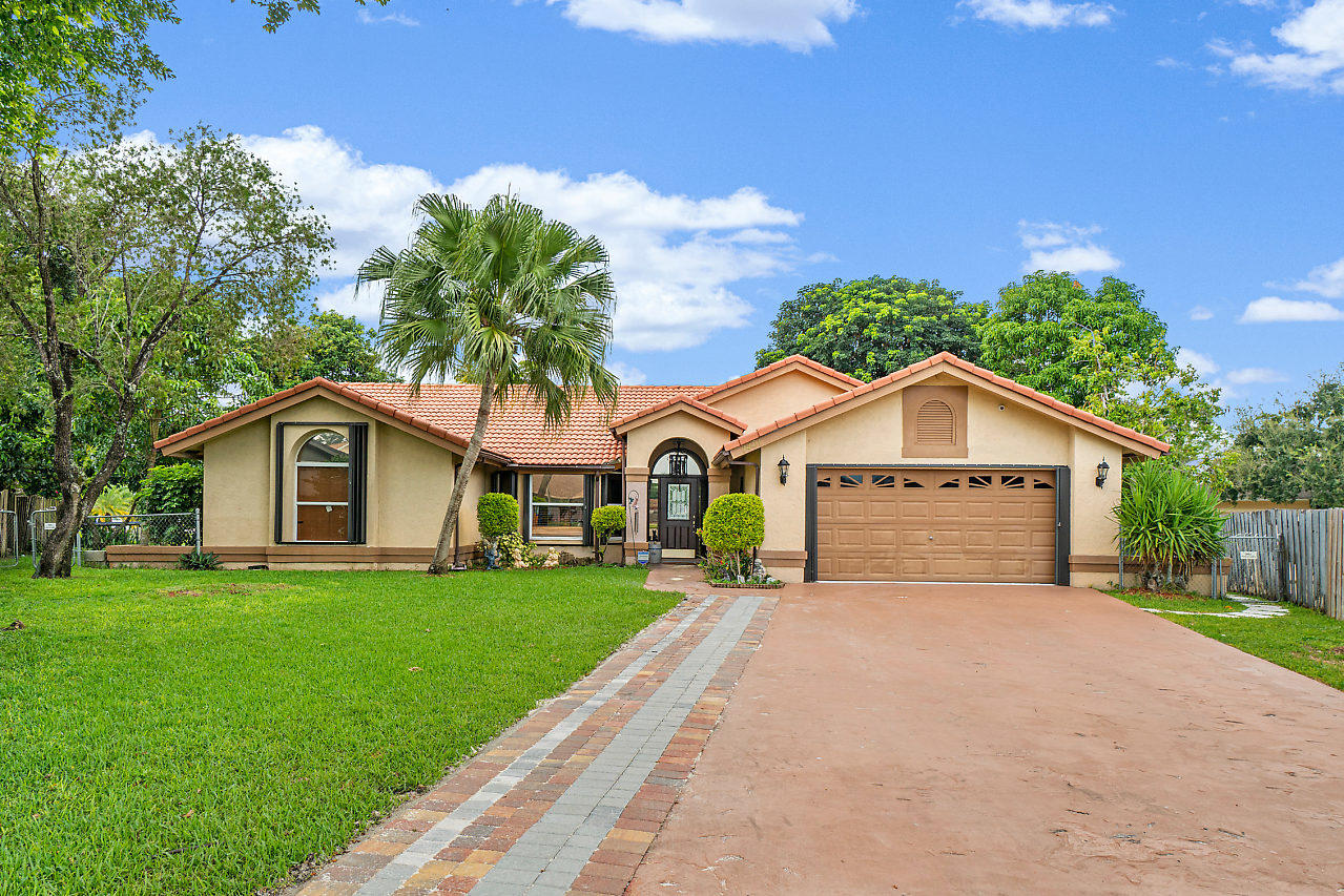 1401 Mystic Court, Unit 1BEDROOM GUESTHOUSE Wellington, FL 33414 - Photo 7 of 12 a front view of a house with a yard and garage