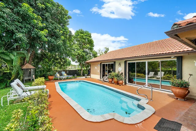 a view of a house with swimming pool and sitting area