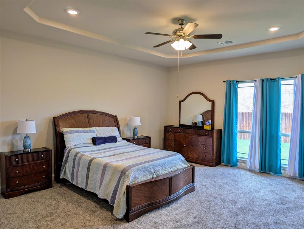 2630 Flat Bush Avenue Midlothian, TX 76065 - Photo 14 of 32 a bedroom with a bed and a dresser with mirror