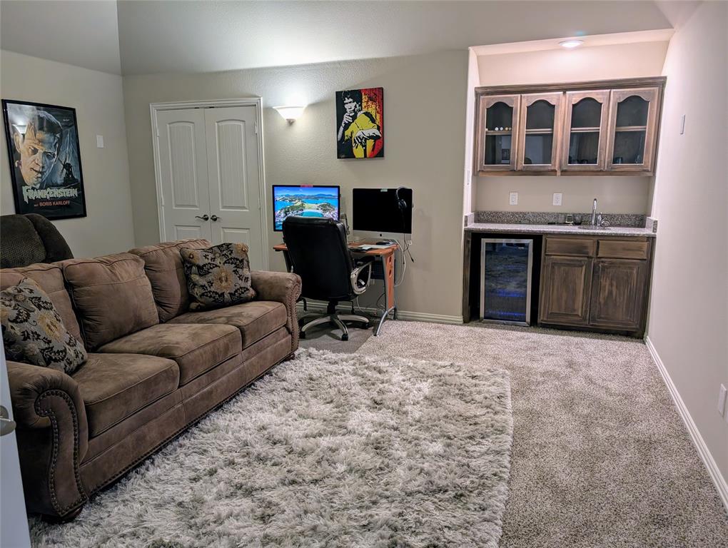 2630 Flat Bush Avenue Midlothian, TX 76065 - Photo 19 of 32 a living room with furniture a fireplace and a flat screen tv