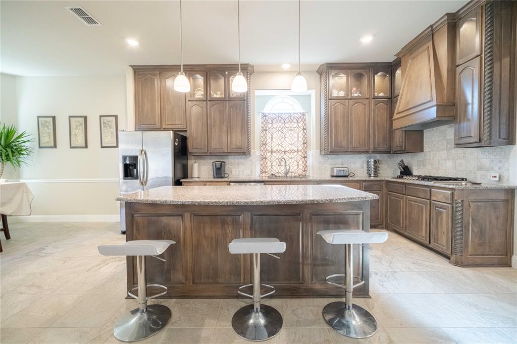 2630 Flat Bush Avenue Midlothian, TX 76065 - Photo 9 of 32 a kitchen with kitchen island granite countertop a table chairs sink and cabinets
