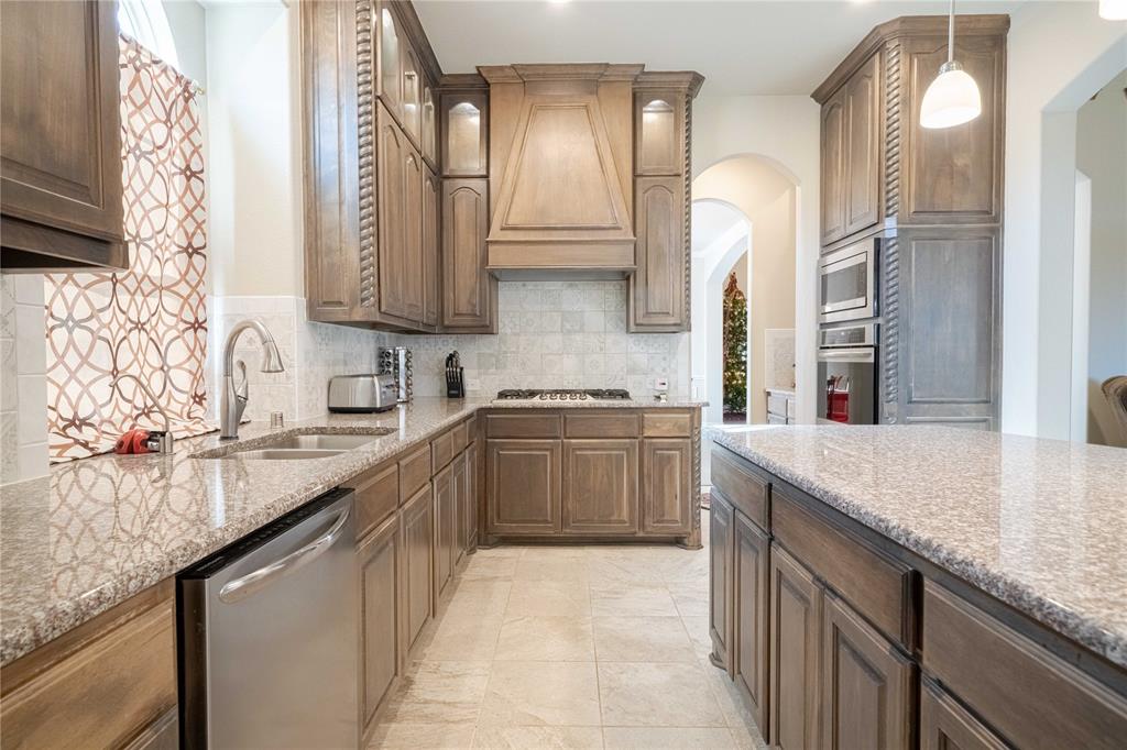 2630 Flat Bush Avenue Midlothian, TX 76065 - Photo 10 of 32 a kitchen with a sink dishwasher a stove and a wooden cabinets