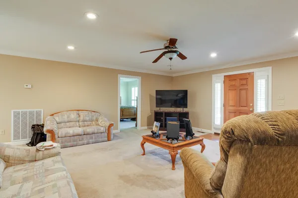 a living room with furniture a flat screen tv and a window