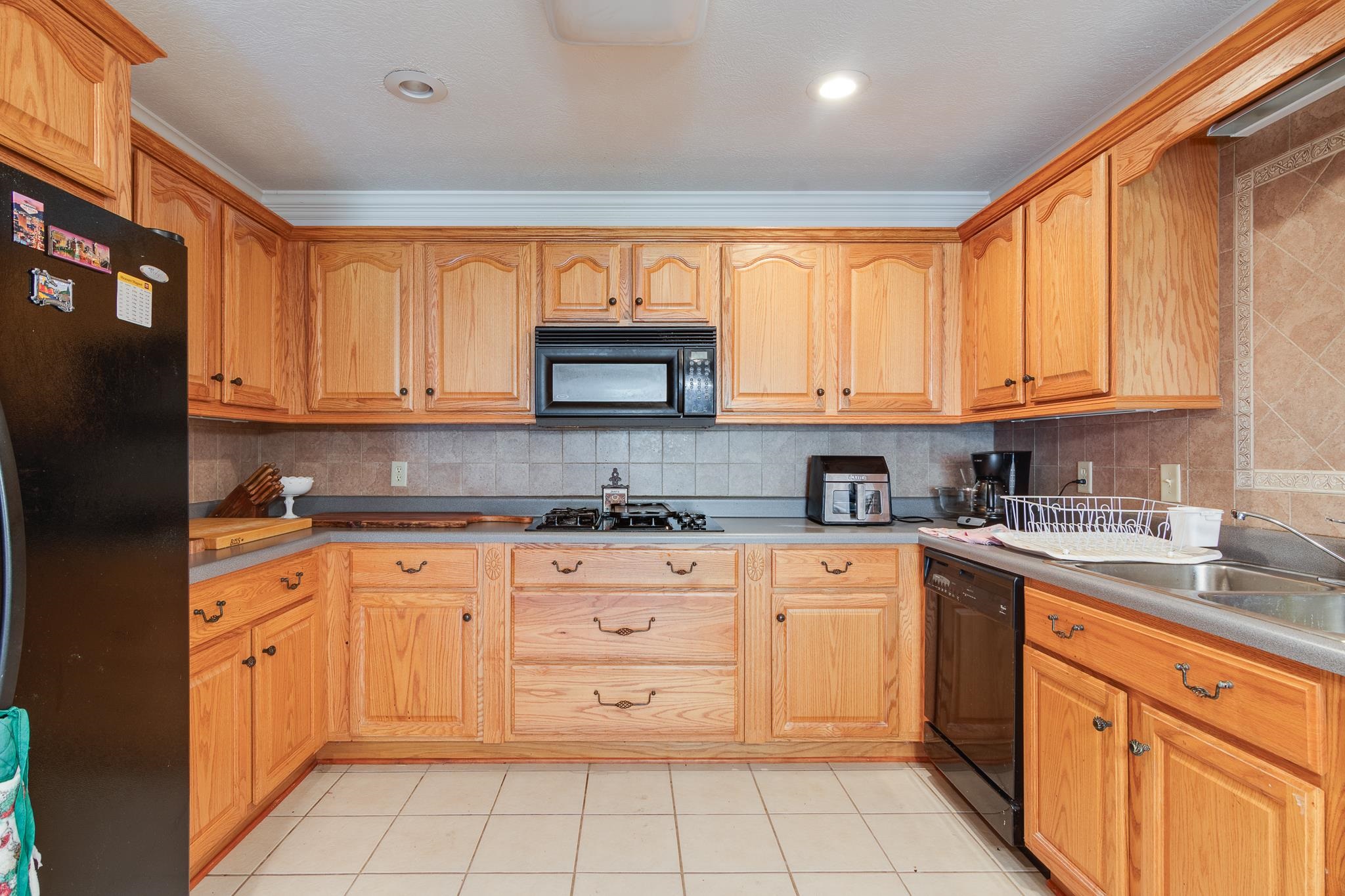 9102 Highway 76 Stanton, TN 38069 - Photo 11 of 27 Kitchen featuring black appliances, decorative backsplash, and light tile patterned flooring