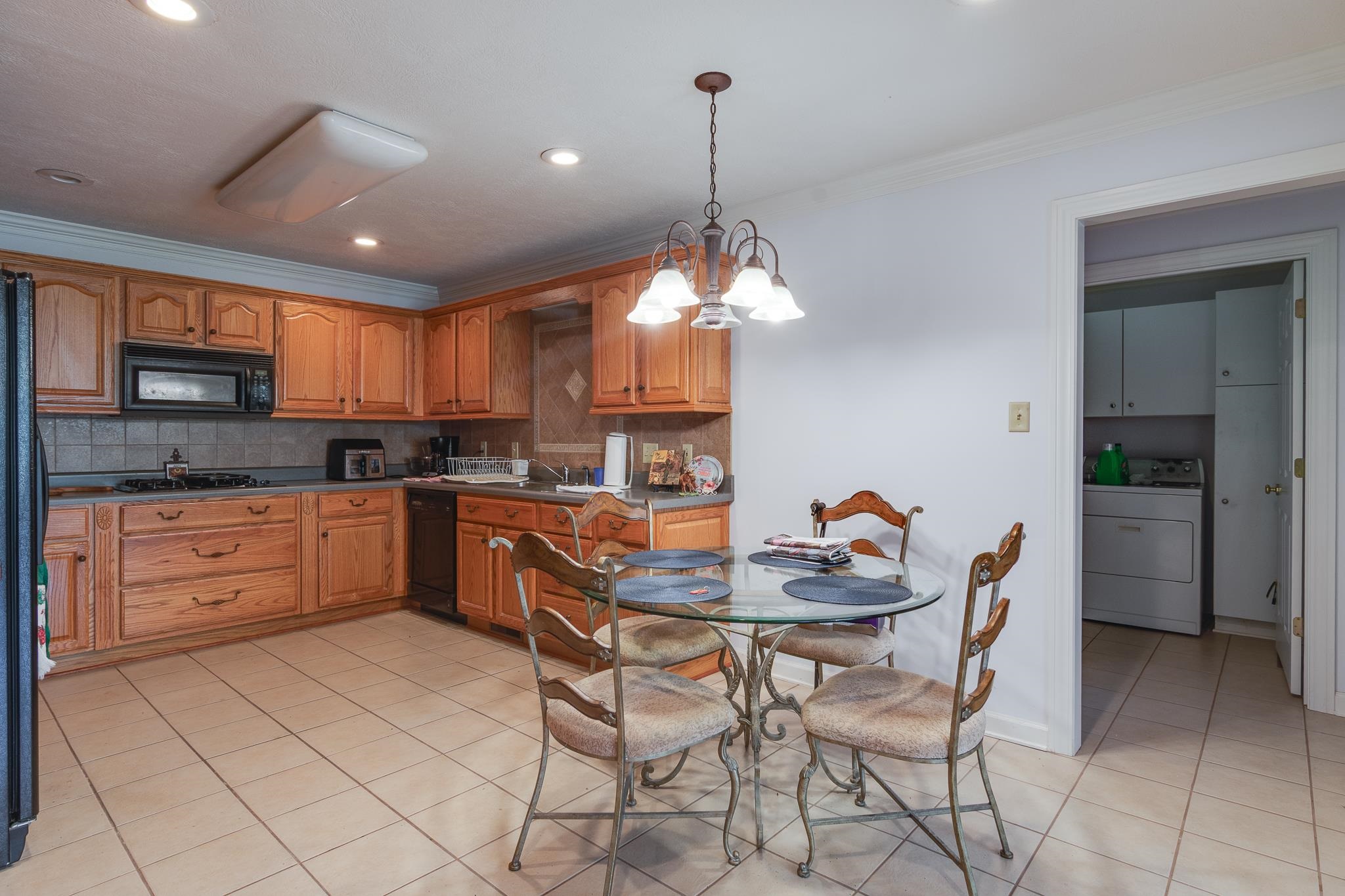 9102 Highway 76 Stanton, TN 38069 - Photo 13 of 27 Kitchen featuring washer / dryer, tasteful backsplash, a chandelier, pendant lighting, and light tile patterned floors