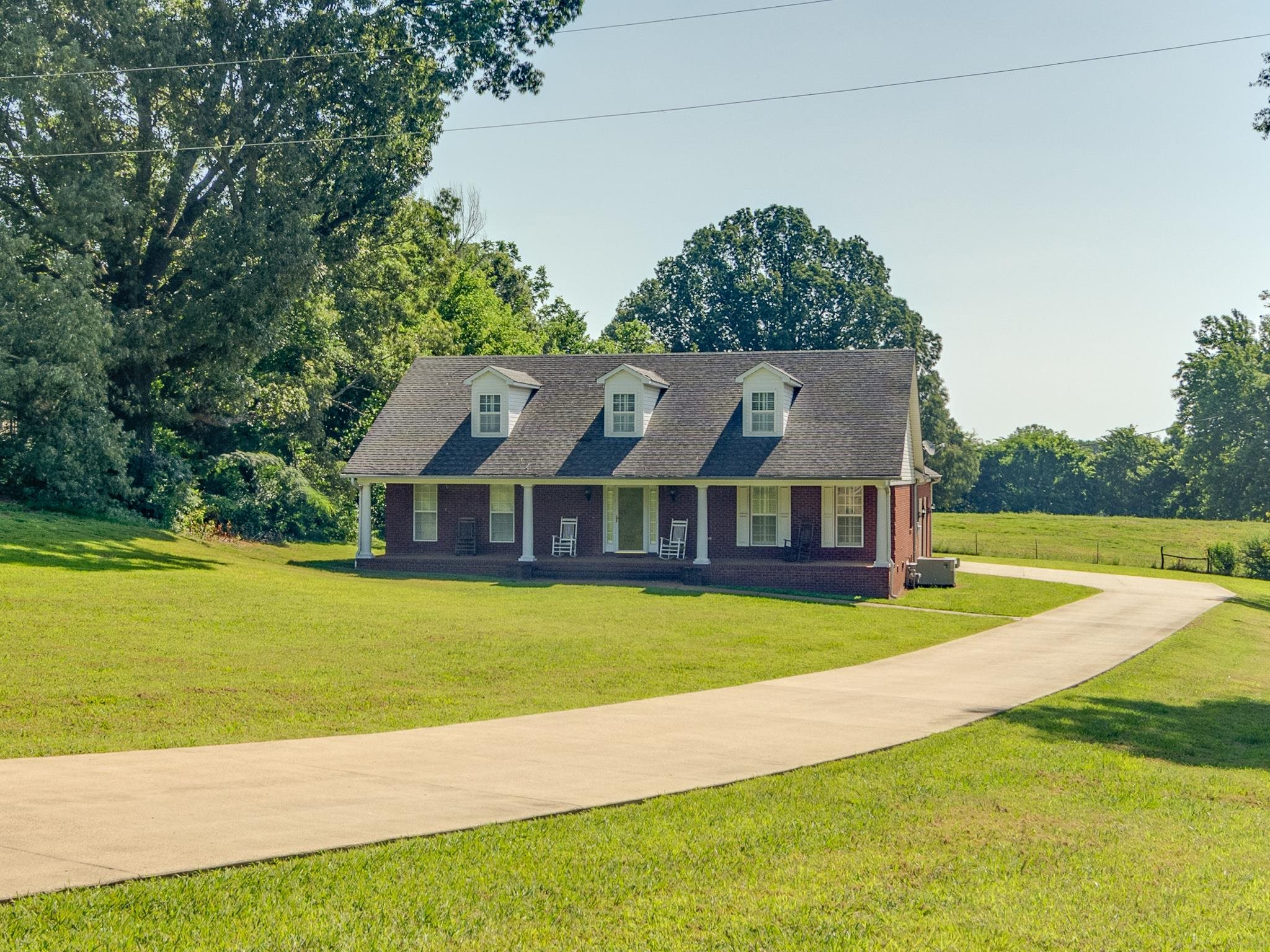 9102 Highway 76 Stanton, TN 38069 - Photo 2 of 27 Cape cod-style house with brick siding, a front yard, a shingled roof, and driveway