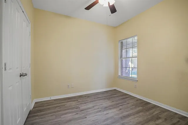 an empty room with a window and wooden floor