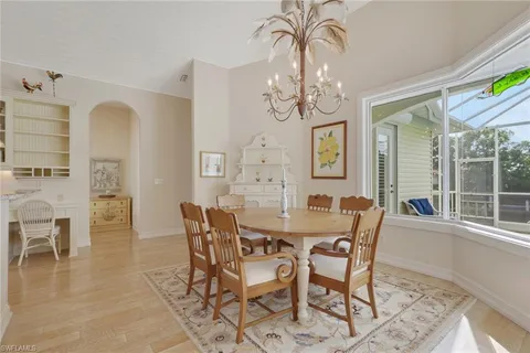 a view of a dining room with furniture a chandelier and wooden floor