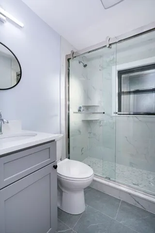 a bathroom with a granite countertop toilet sink and shower