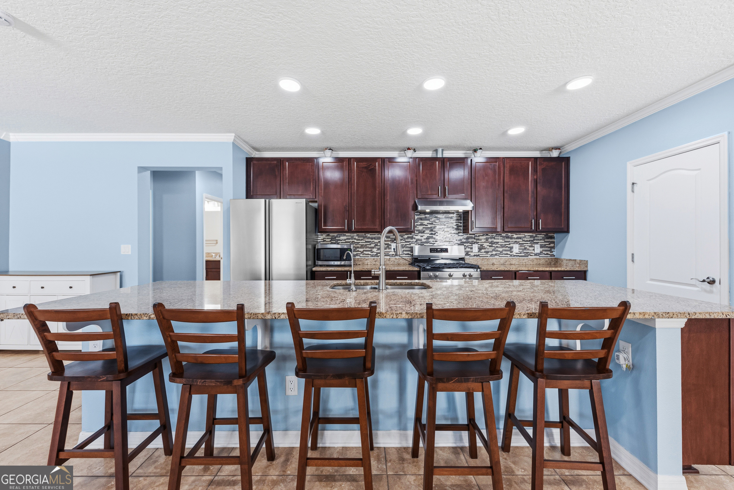 135 Walnut Way Kingsland, GA 31548 - Photo 16 of 35 a dining area with stainless steel appliances kitchen island granite countertop a dining table chairs and a refrigerator