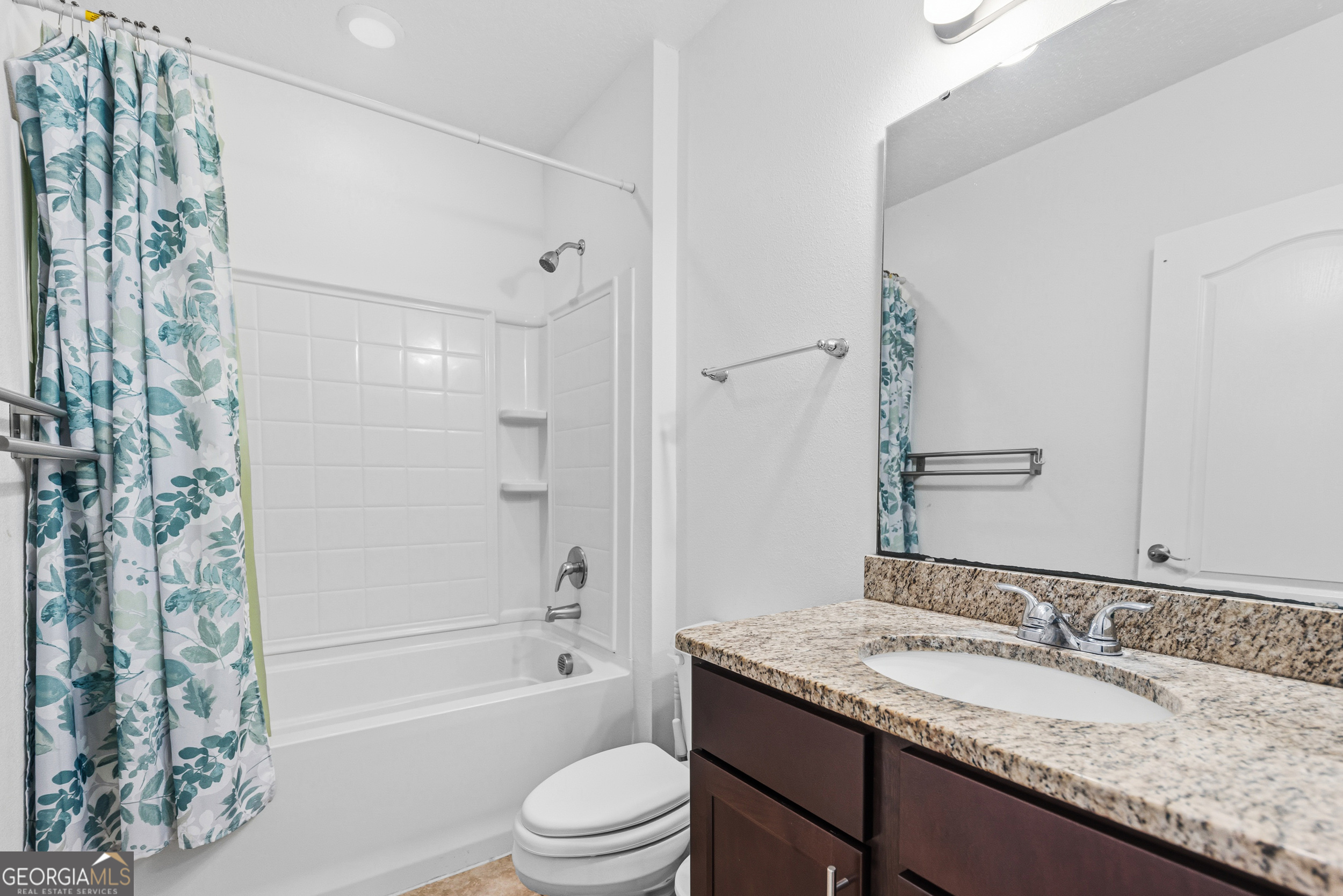 135 Walnut Way Kingsland, GA 31548 - Photo 22 of 35 a bathroom with a granite countertop sink a toilet a mirror a bathtub and shower