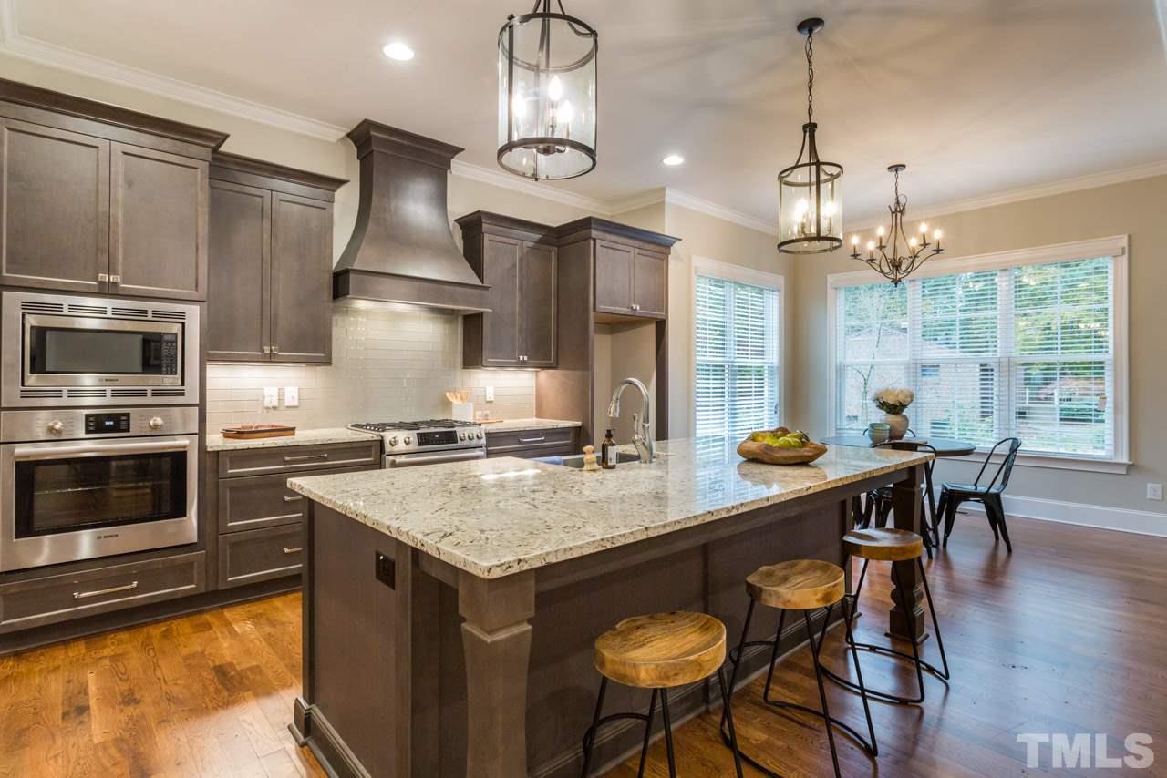 4613 Pleasant Pointe Way Raleigh, NC 27613 - Photo 3 of 25 a kitchen with stainless steel appliances granite countertop a sink a stove a dining table and chairs
