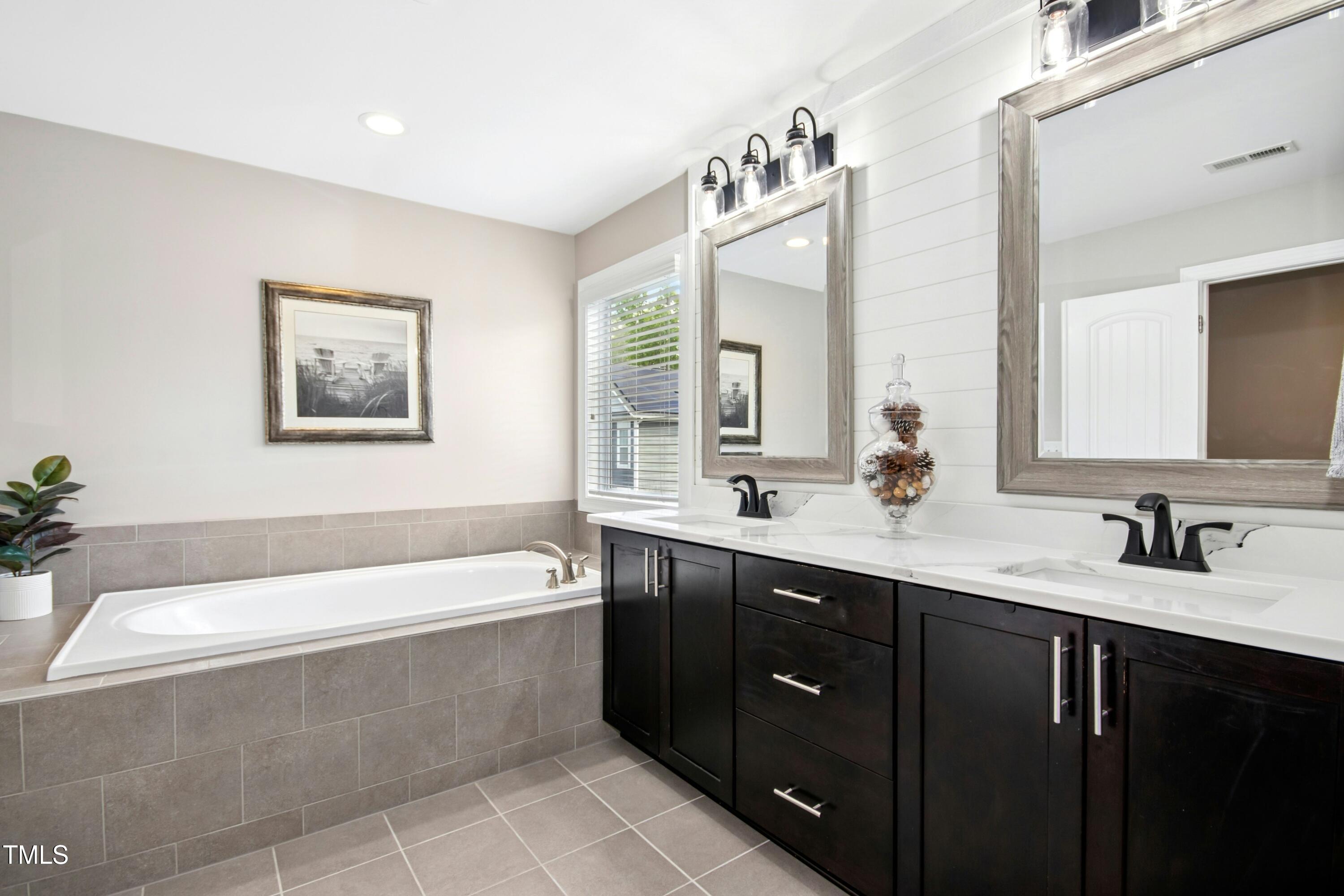 44 South Wilders Ridge Way Clayton, NC 27527 - Photo 27 of 56 a bathroom with a tub a sink and mirror