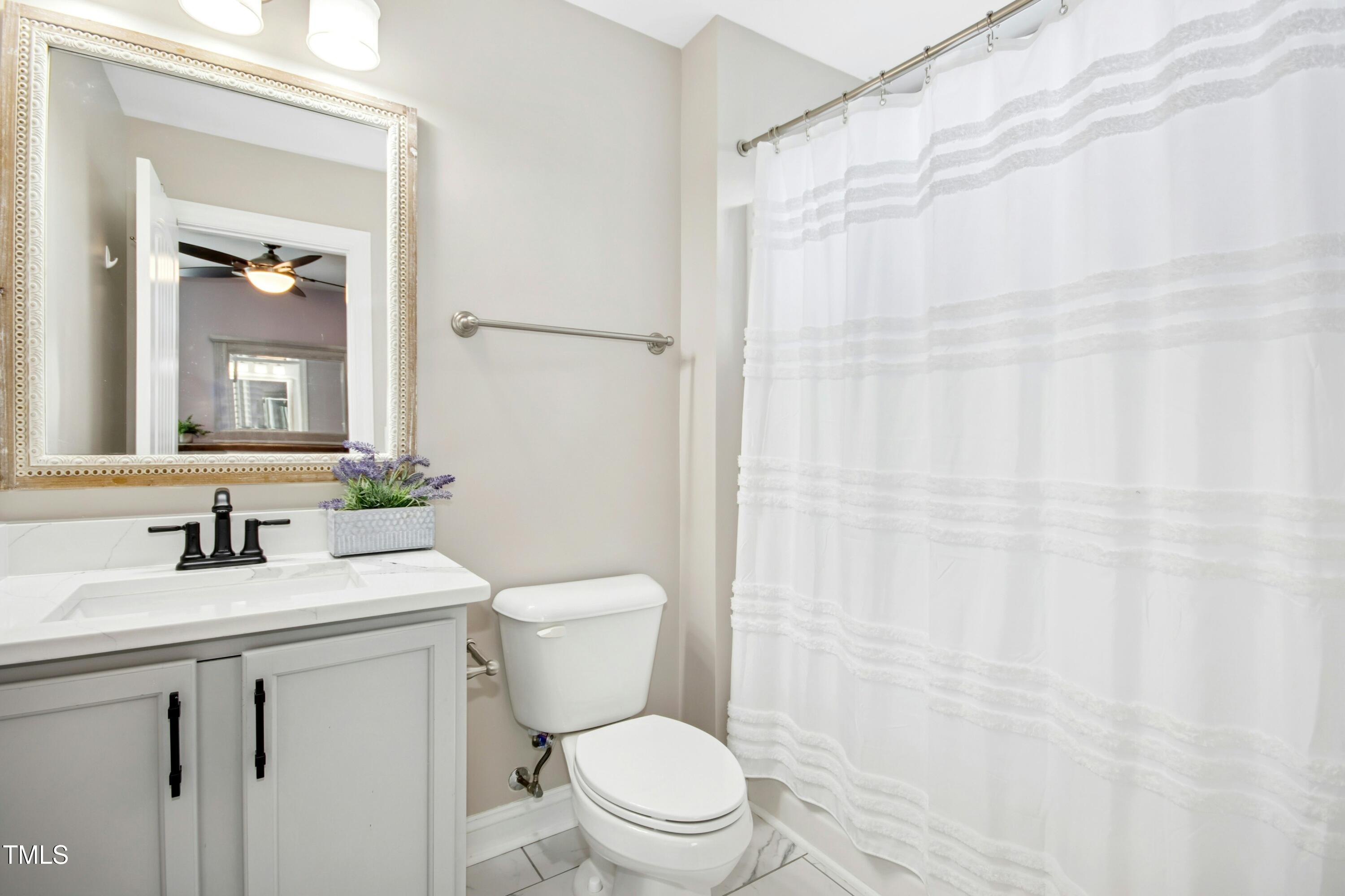 44 South Wilders Ridge Way Clayton, NC 27527 - Photo 30 of 56 a bathroom with a sink a toilet and shower curtain