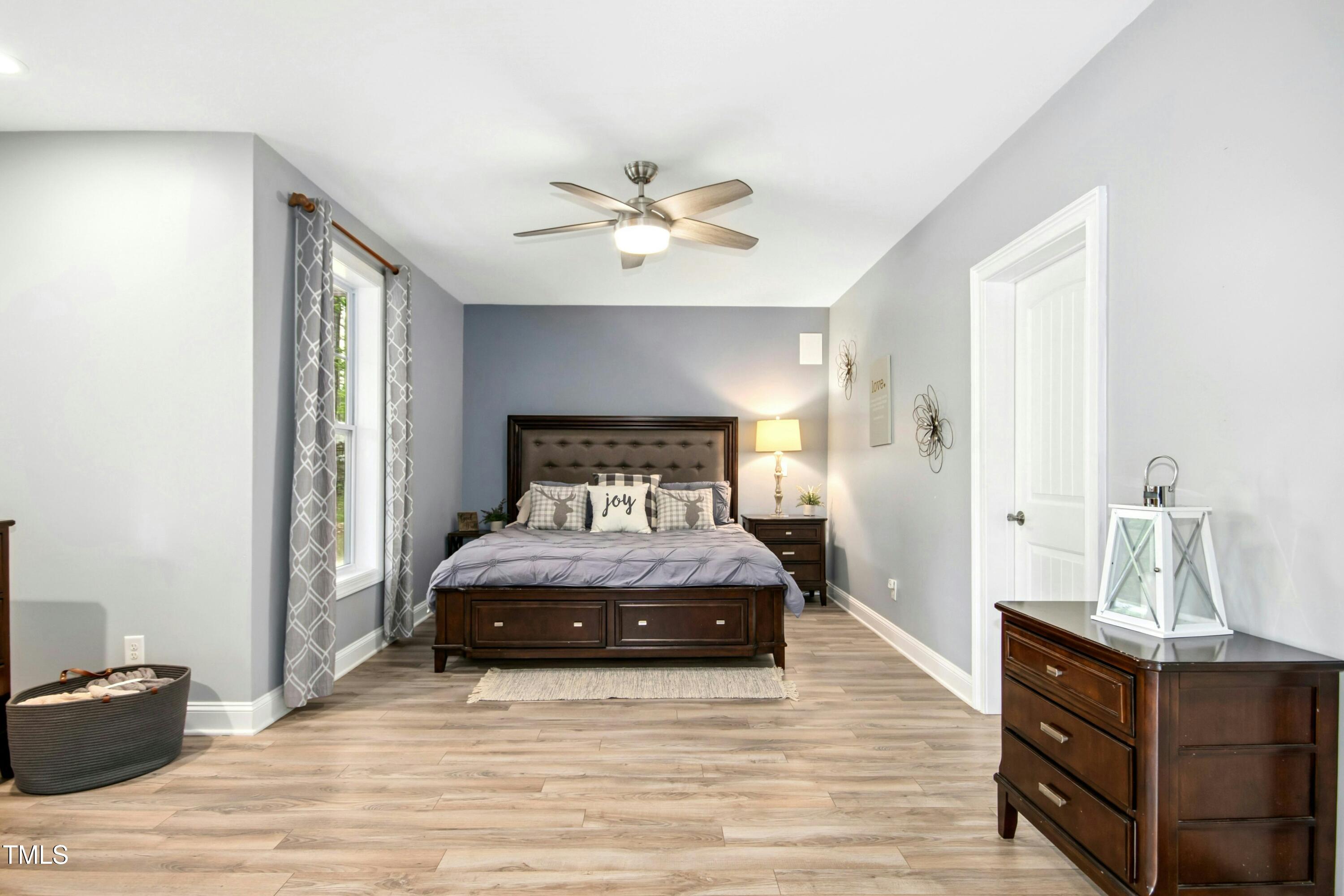 44 South Wilders Ridge Way Clayton, NC 27527 - Photo 40 of 56 a bedroom with a bed and wooden floor