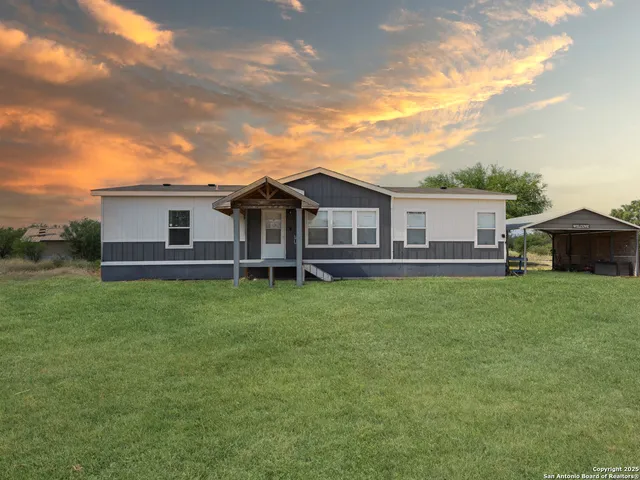 a view of a house with a backyard