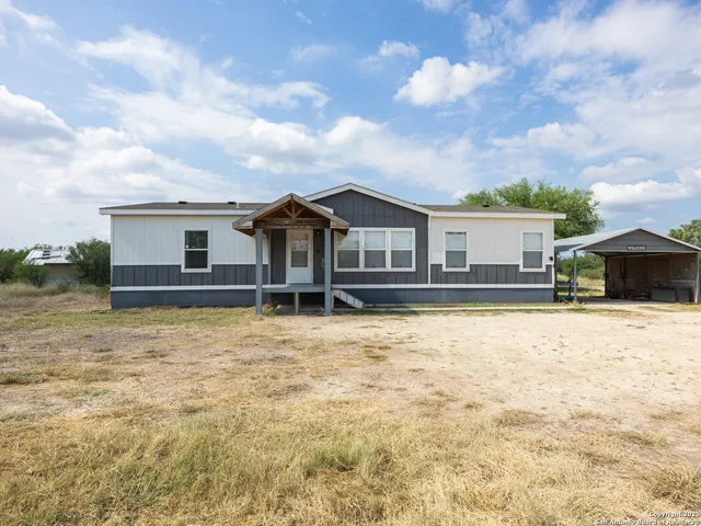 a view of a house with a yard and sitting area