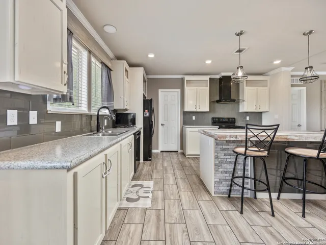 a kitchen with granite countertop a sink a counter top space stainless steel appliances and a window
