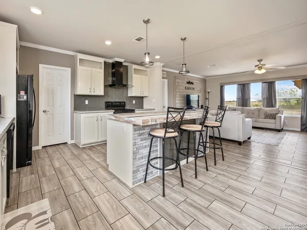a large kitchen with cabinets table and chairs