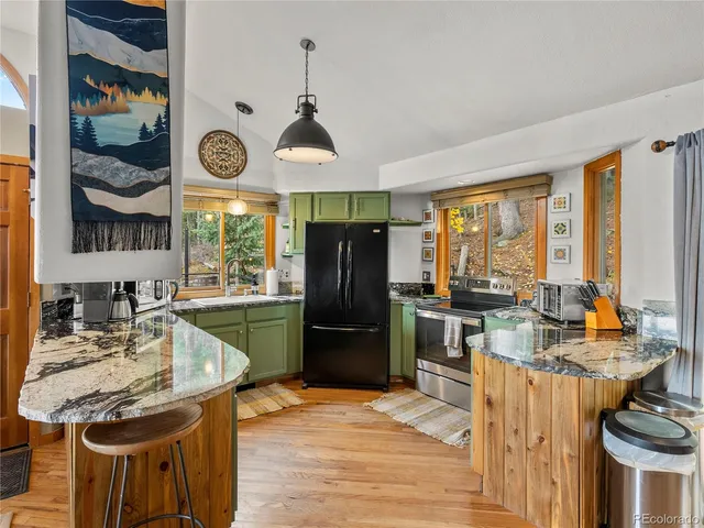 a kitchen with stainless steel appliances granite countertop a stove refrigerator and cabinets